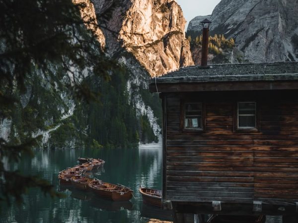 A small cabin sitting on top of a lake next to a mountain